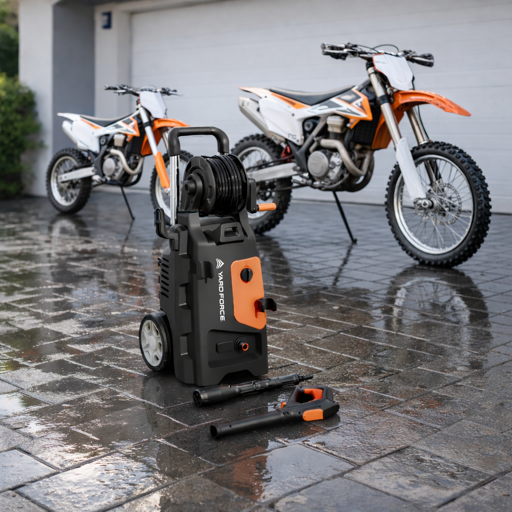 High-pressure washer on a wet driveway with dirt bikes in the background